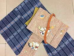 青地格子生紬と臙脂疋田地に唐子人形刺繍名古屋帯