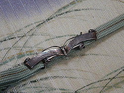 霞に芝模様開き名古屋帯に蝶の帯留