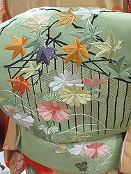 鶸色に秋の庭図名古屋帯