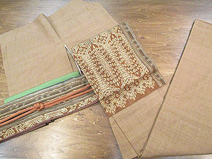 ベージュ地無地紬（一つ紋）にカリマンタン名古屋帯