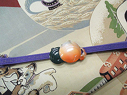 おもちゃ尽しの帯に出雲石とメノウの鈴帯留